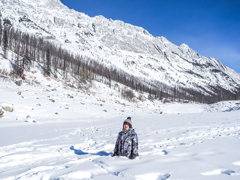 A boy in snow up to his waist at Medicine Lake in winter
