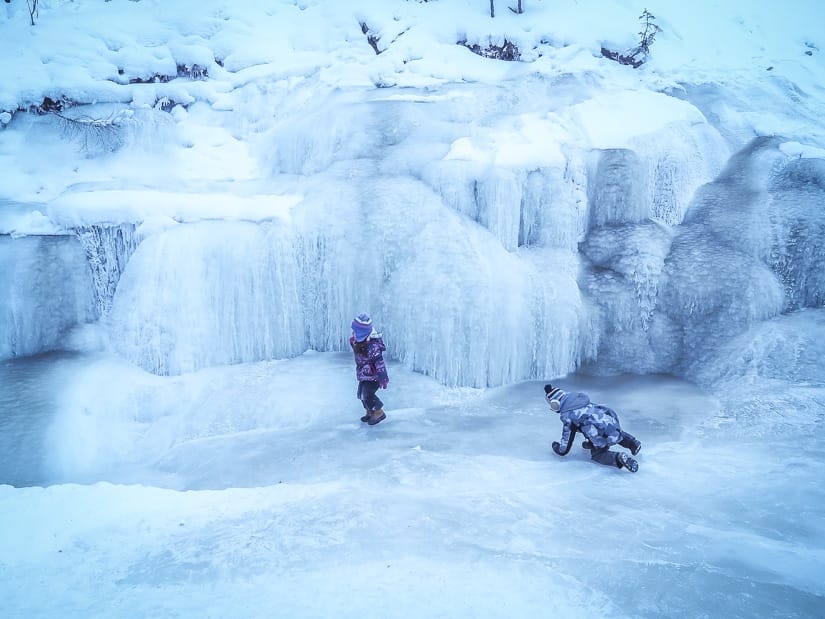 Two kids walking on a frozen stream in Maligne Canyon, Jasper