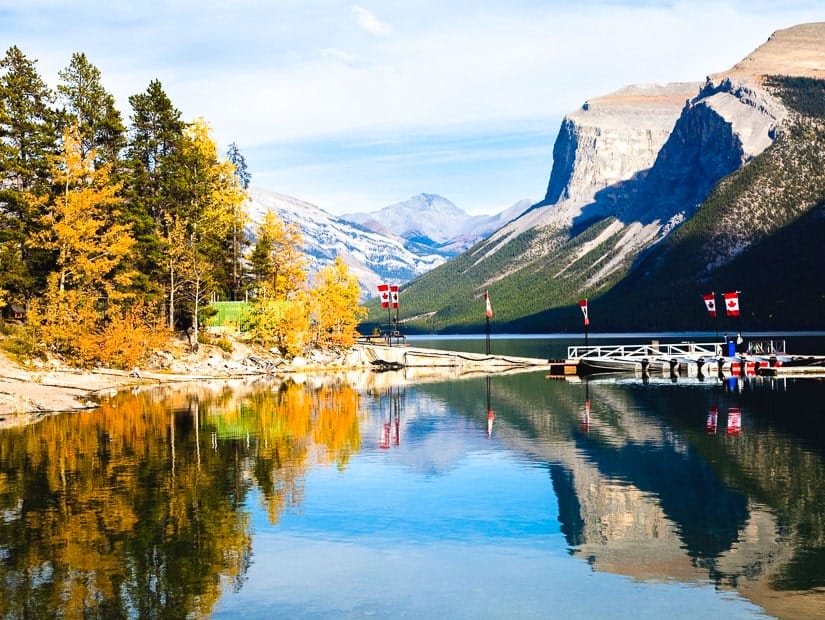 Boat launch and Canadian flags at Lake Minnewanka with fall colors
