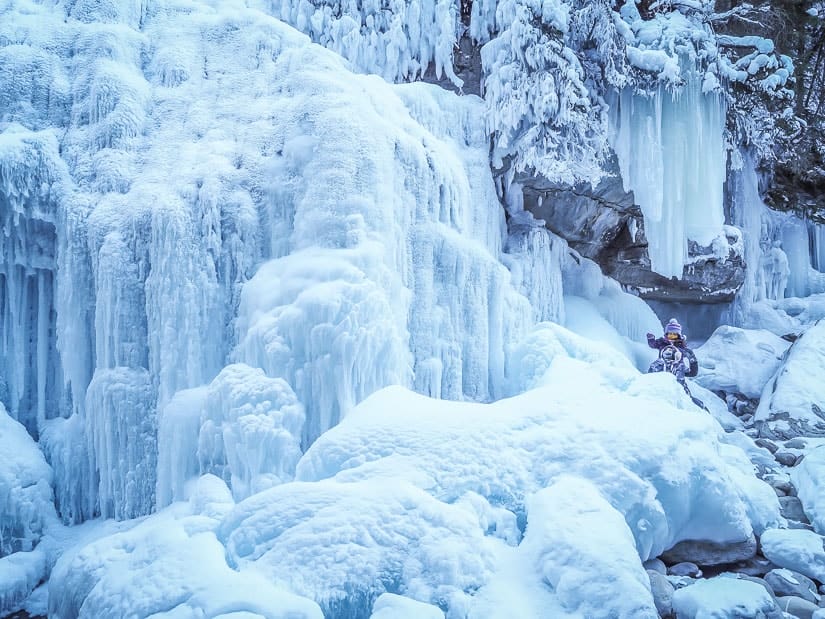 Two kids surrounded by frozen waterfalls and ice on the Maligne Canyon Icewalk in Jasper National Park