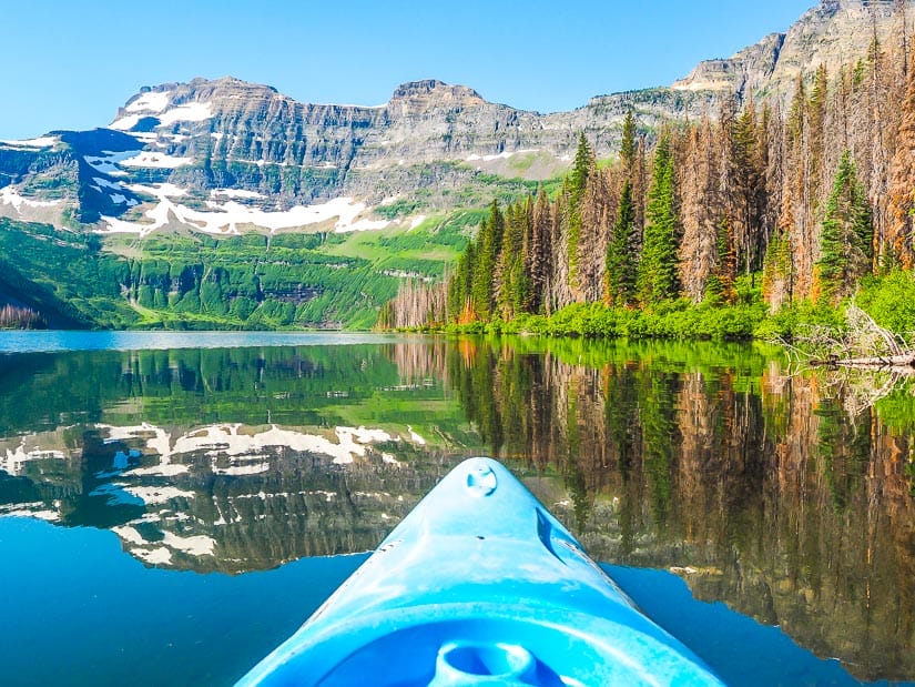 A kayak on Cameron Lake with the mountains and trees reflecting on the water