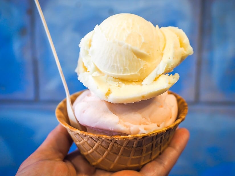 A hand holding a double scoop of ice cream from Ross Street Ice Cream, the best ice cream in Red Deer