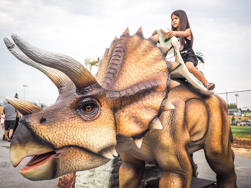 Kid riding a dinosaur at Abbotsford Agrifair