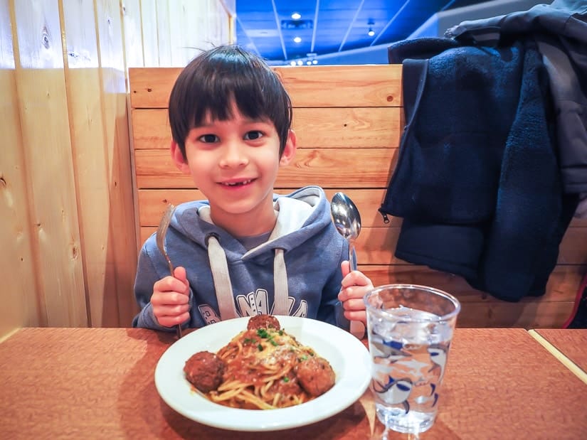 A kid eating spaghetting in a family-friendly restaurant in Jasper