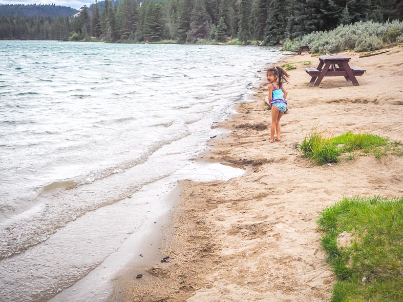 A kid playing on the beach at Annette Lake in Jasper