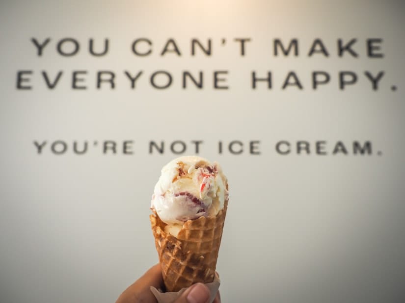 Hand holding an ice cream with words behind it at Banter Ice Cream, which has the best ice cream in Abbotsford