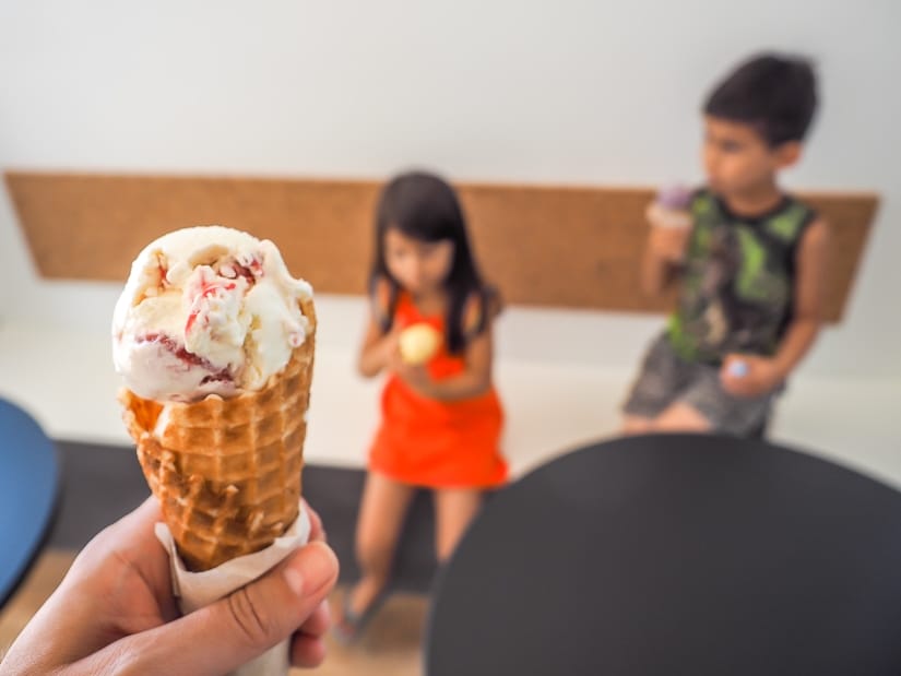 Ice cream cone with two kids in background