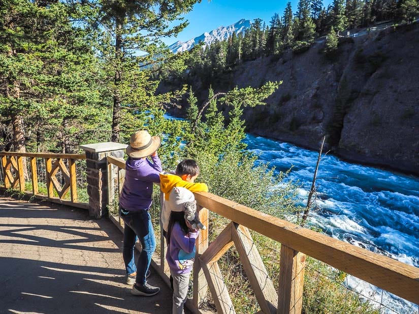 A family looking at a waterfall on Bow Falls Trail, one of the best hikes in Banff for kids