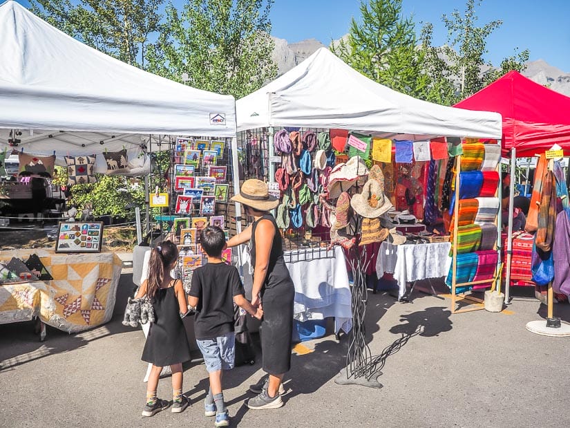 A woman and two kids looking at products at the Canmore Mountain Market, the Canmore Farmers' Market