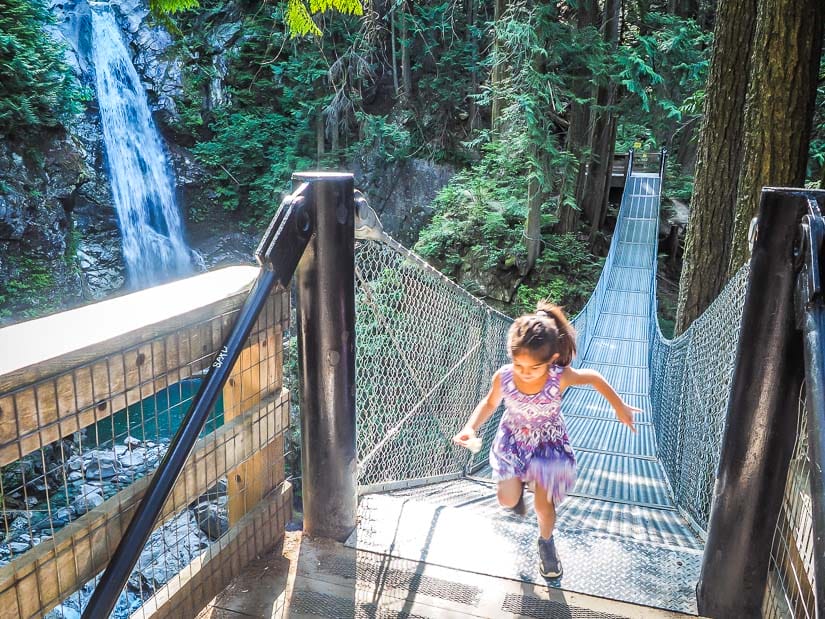 Girl running across suspension bridge at Cascade Falls