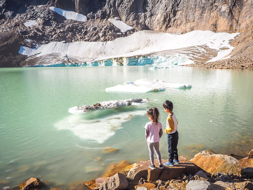 Two kids looking at floating ice at Cavell Pond, one of the best hikes with kids in Jasper