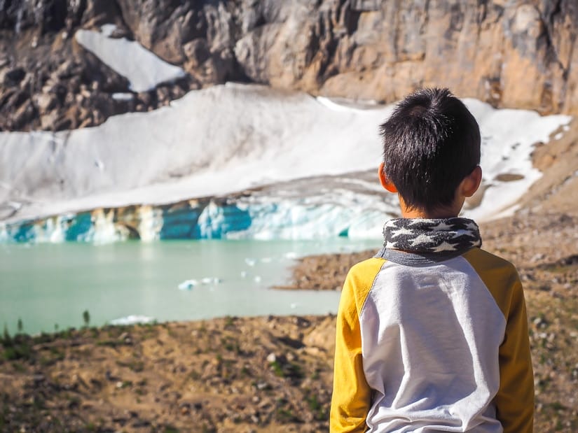 A kid looking down at Cavell Pond with snow beside it