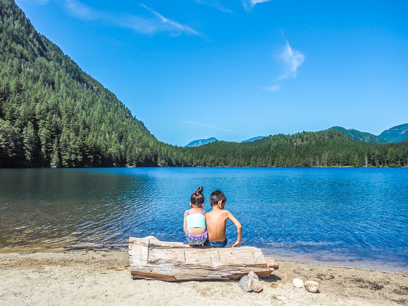 Two kids sitting on a log at Davis Lake BC