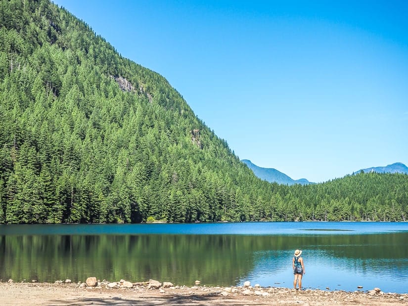 A woman standing on the shore at Davis Lake, one of the most beautiful lakes near Abbotsford, British Columbia