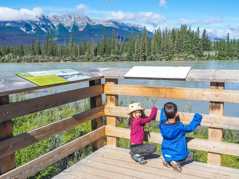 Two kids looking over the Athabasca River at Jasper House National Historic Site