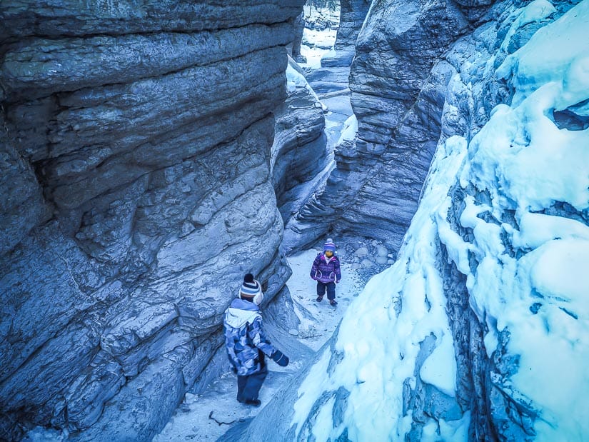 Two kids walking through Maligne Canyon in winter