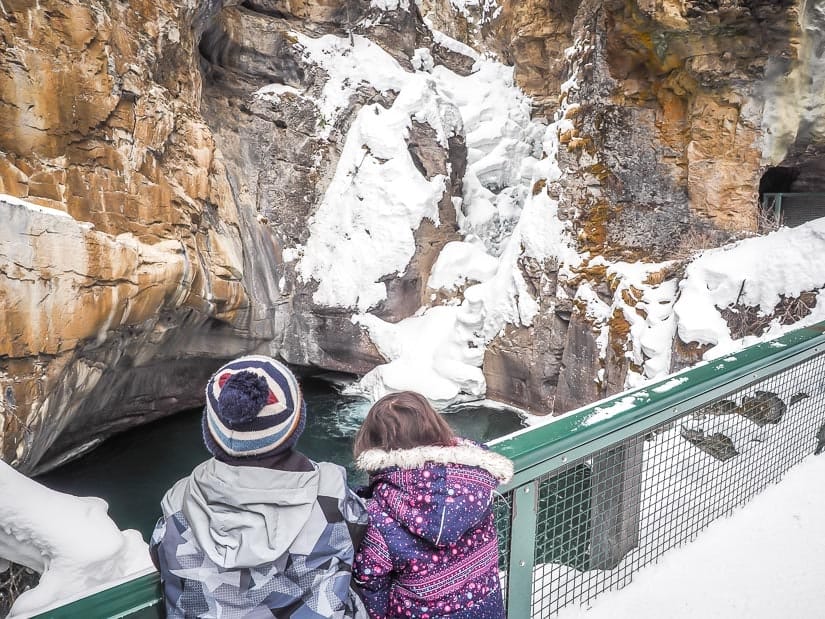 Two kids looking at Lower Falls in Johnston Canyon in winter