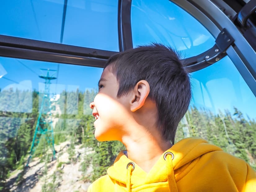 A kid looking out the window of the Banff Gondola