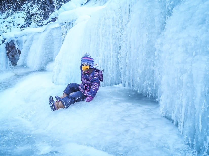A kid sitting on the ice in Maligne Canyon Ice Walk