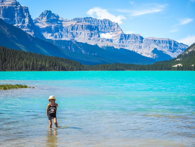 A kid standing in the water at Waterfowl Lakes Campground