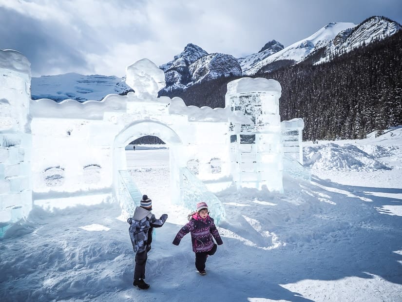 Two kids running into an ice castle at Lake Louise Ice Magic Festival