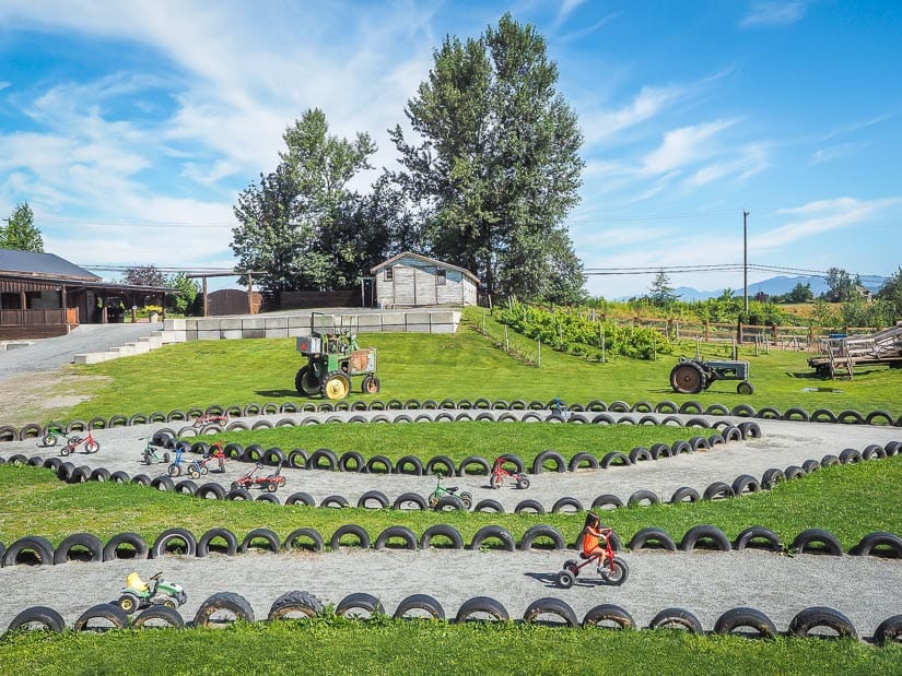 A girl riding a tricycle on a track at Maan Farms Abbostsford