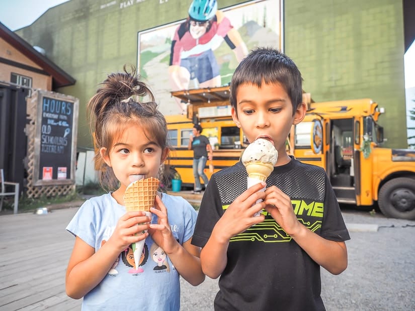 Two kids eating ice cream cones at Old School Bus Ice Cream, some of the best ice cream in Canmore