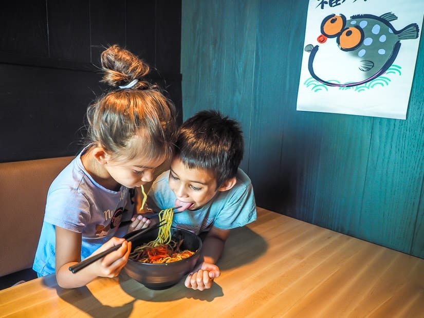 Two kids eating noodles in a kid-friendly Japanese restaurant in Banff