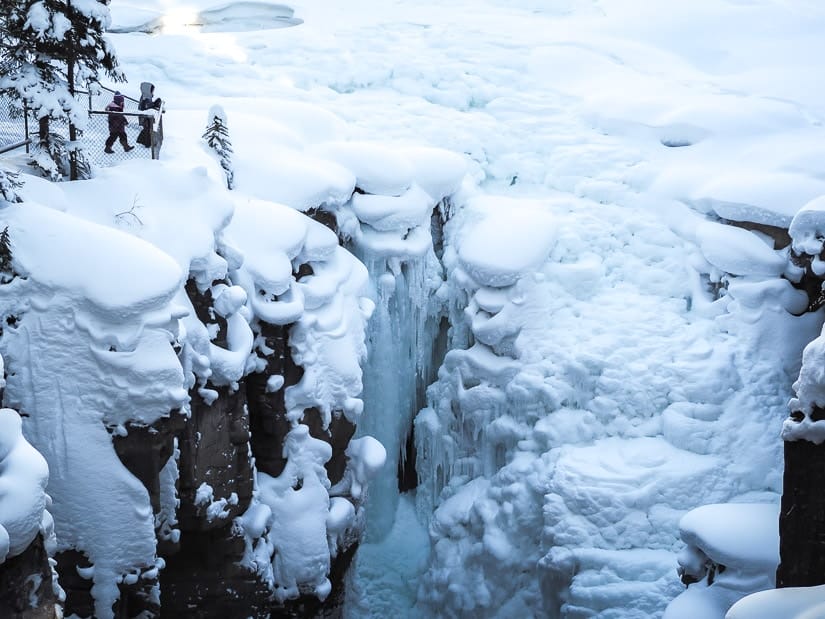 Two kids looking down at Sunwapta Falls in winter