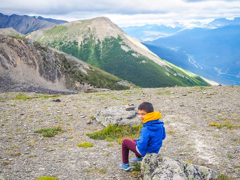 A kid sitting at the peak of Whistler's Mountain after riding the Jasper Skytram