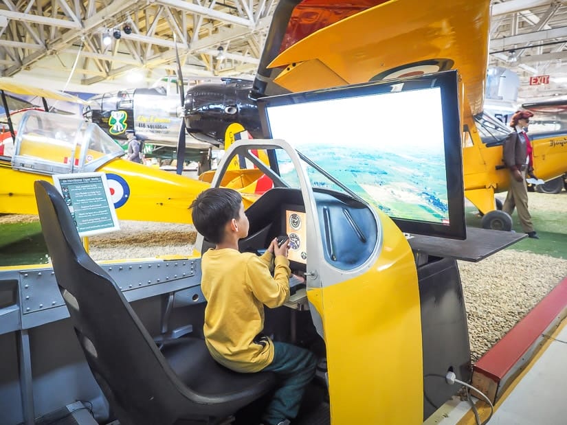 A kid playing a flight simulator at Alberta Aviation Museum