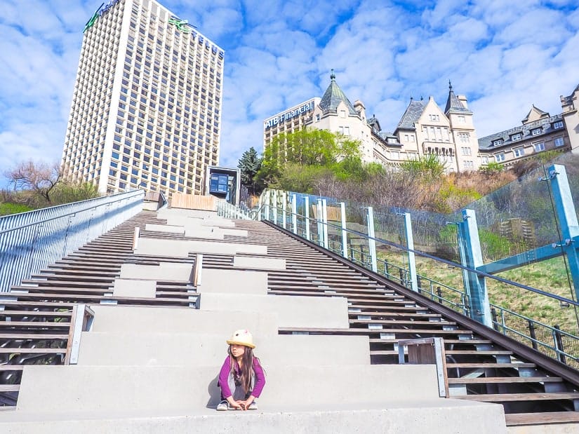 Kid sitting on the steps beside the Edmonton Funicular