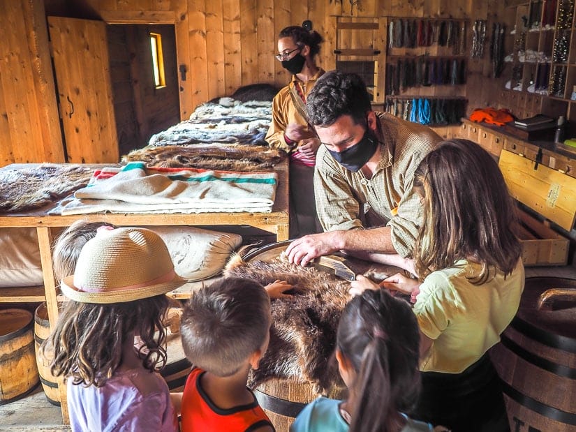 An interpreter showing some furs to kids at Fort Edmonton Park