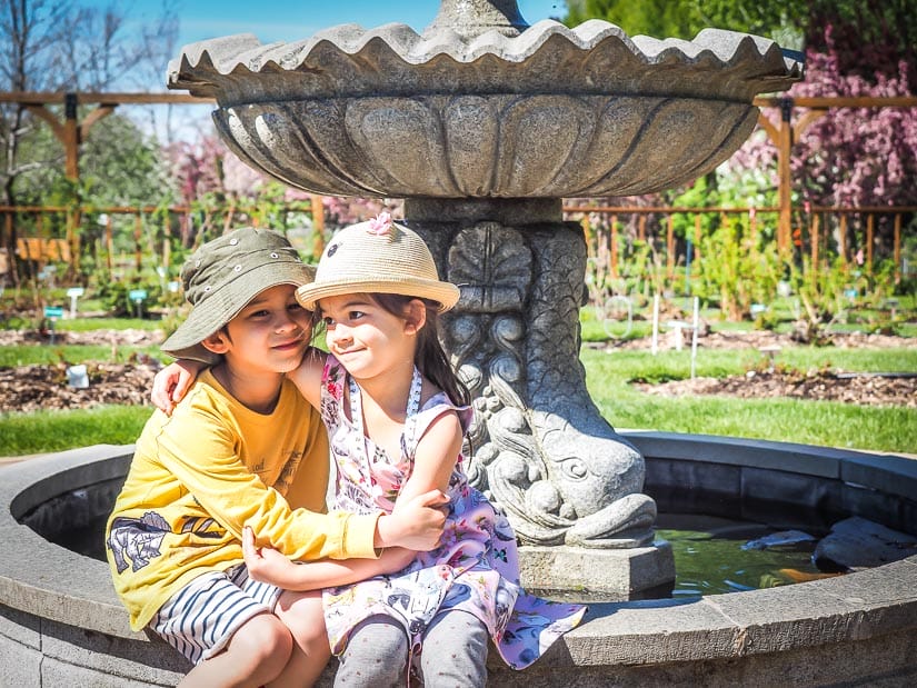Kids sitting on a fountain in Fountain at St. Albert Botanic Park