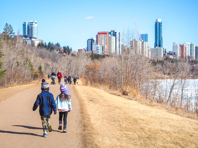 Two kids walking along a path beside the river in Edmonton