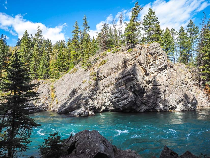 A cliff and rapids on Kananaskis River at Canoe Meadows