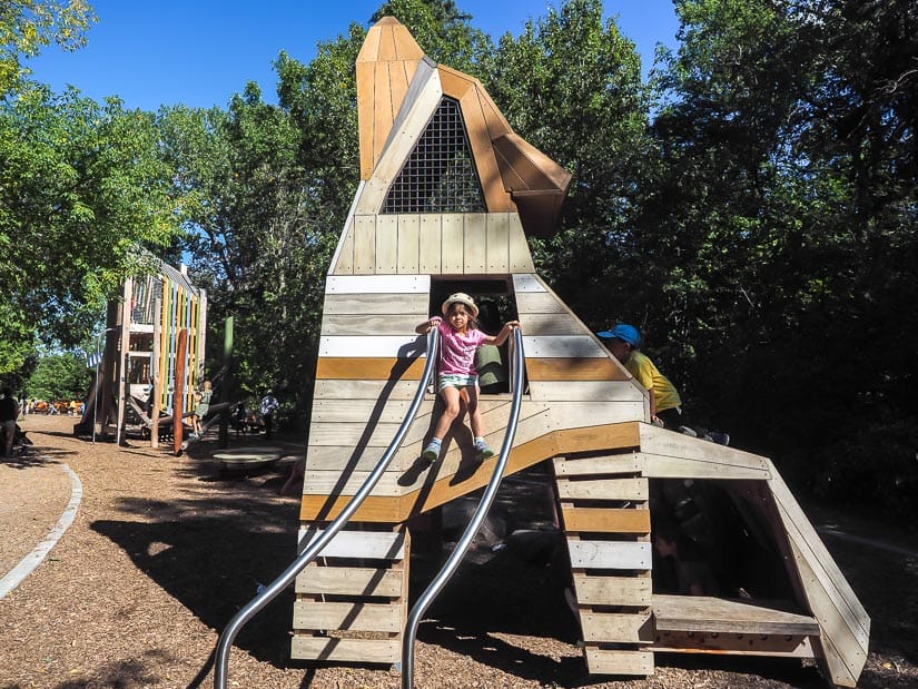 A girl sitting in a coyote-shaped tower at Natural Playground in Sir Wilfred Laurier Park