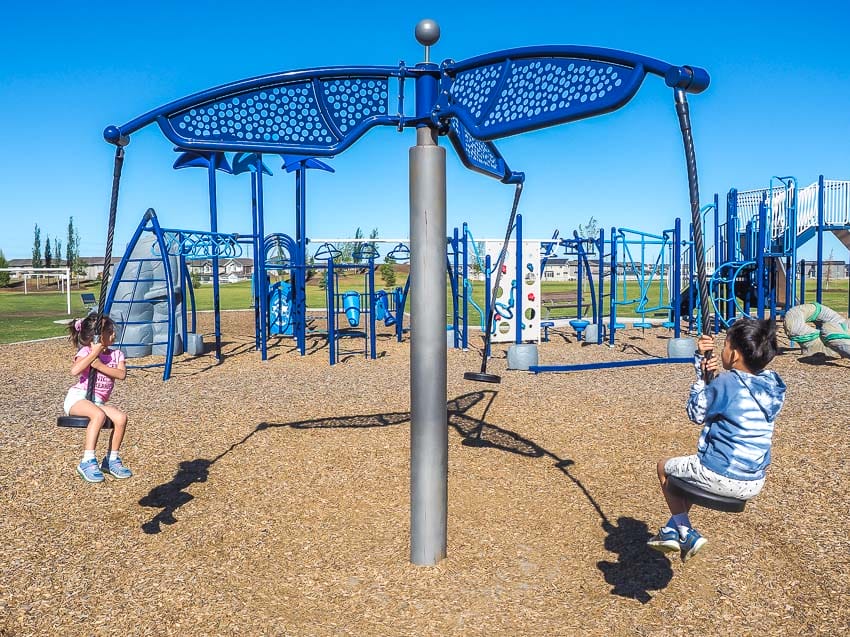 Two kids on a swing at Svend Hansen School Playground in Edmonton