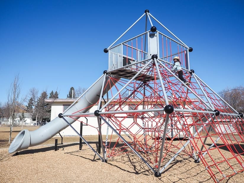 A kid climbing a rope tower at Westglen School Playground Edmonton