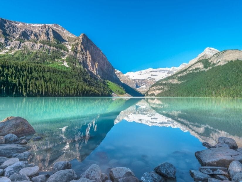 View from the shore of Lake Louise with the mountains reflecting in the water