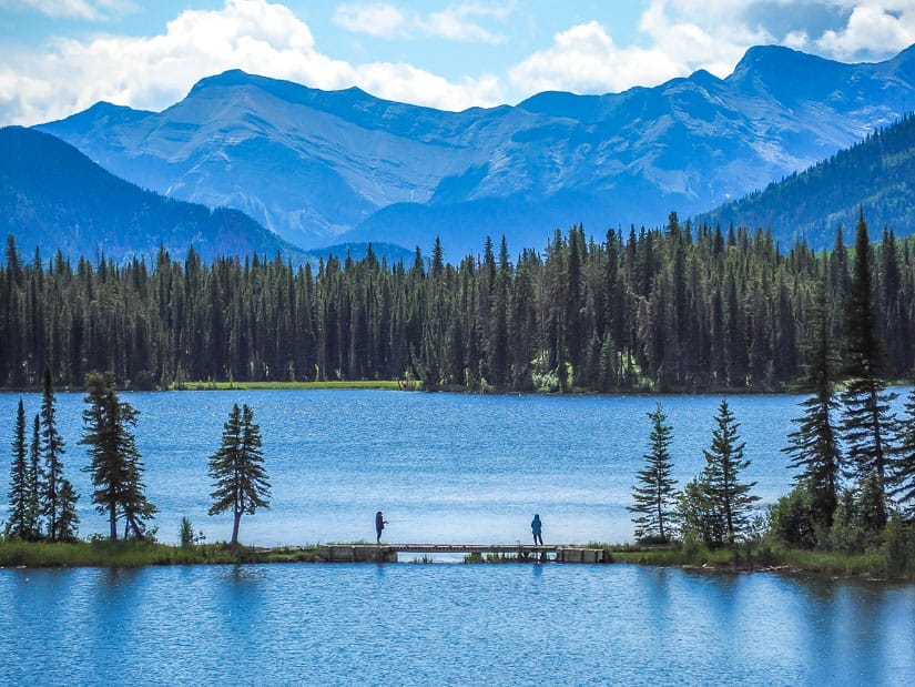 A lake with people fishing on the dock in William A. Switzer Provincial Park