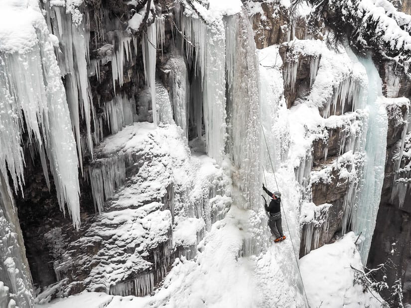 An ice climber climbing a frozen waterfall in Maligne Canyon