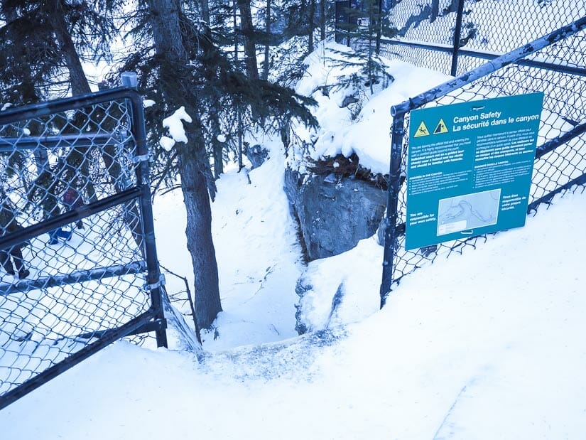 An open gate with a warning sign on it, the entrance gate to Maligne ice walk
