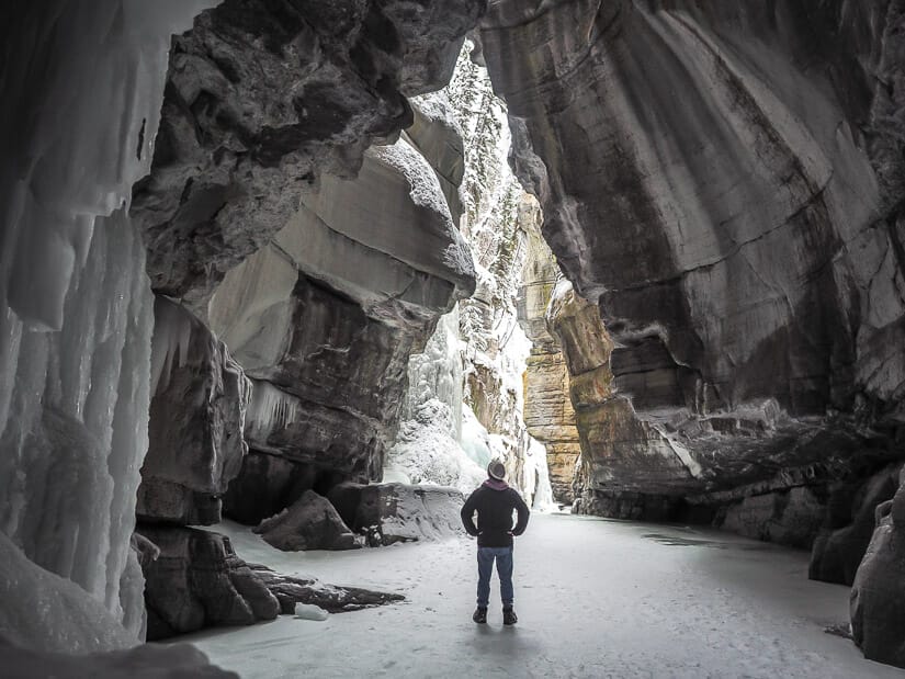 A person standing in frozen Maligne Canyon