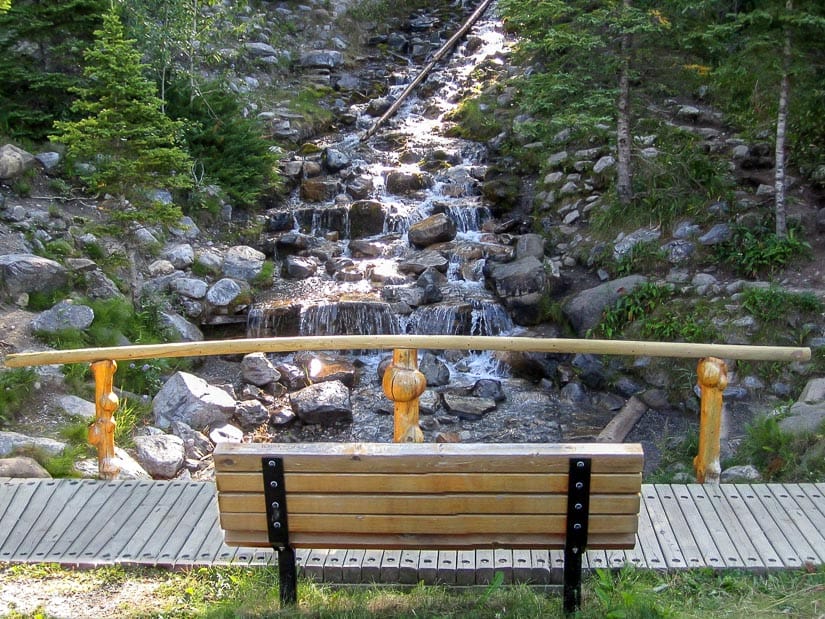 A bench in front of O'Shaughnessy Falls in Kananaskis Alberta