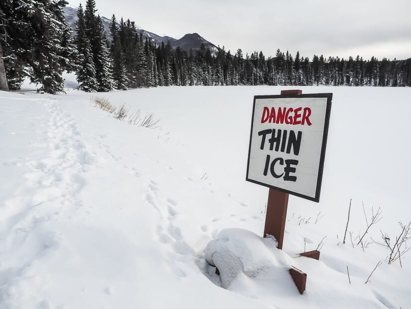 A winter walking trail around Beauvert Lake in Jasper, with a sign that says "Danger Thin Ice"