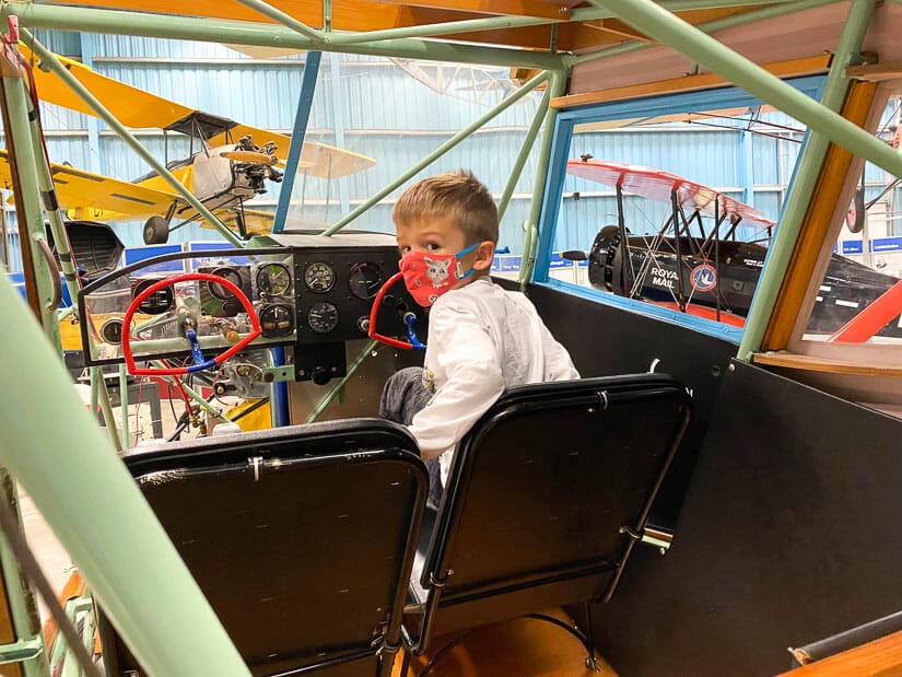 A kid inside the cockpit of a plane at Reynolds Museum Alberta