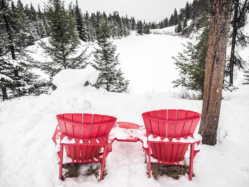 Two red Parks Canada chairs on the Valley of the Five Lakes Jasper hiking trail in winter