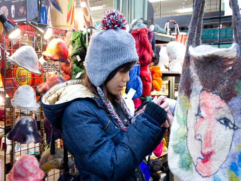 A woman taking photos in a farmers market in Edmonton in winter