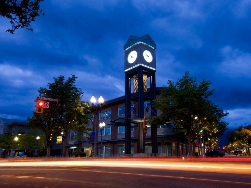 Clock tower in Chilliwack city centre at night, with lights from cars going by